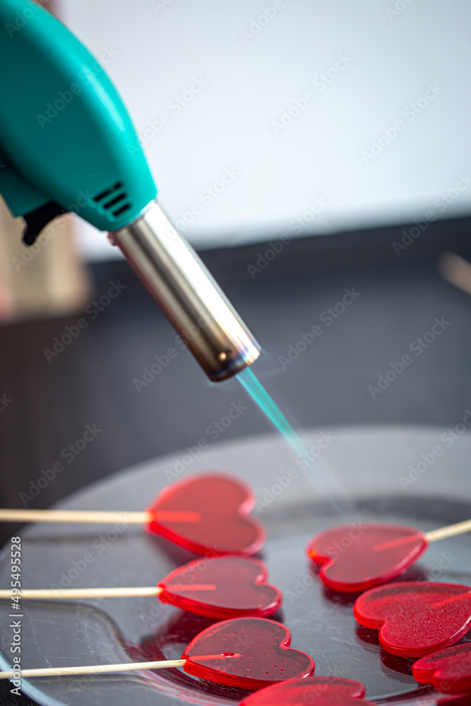 Close-up, the process of making heart-shaped lollipops. Close-up, the process of making heart-shaped lollipops.
