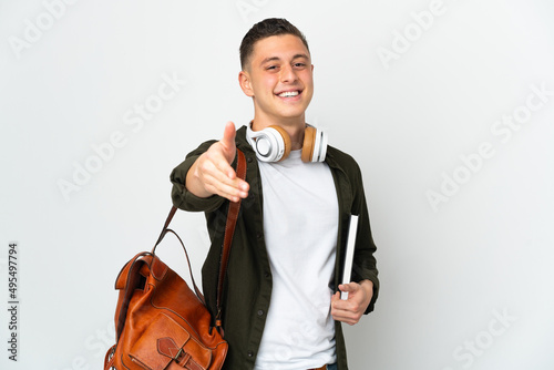 Young caucasian student man isolated on white background shaking hands for closing a good deal
