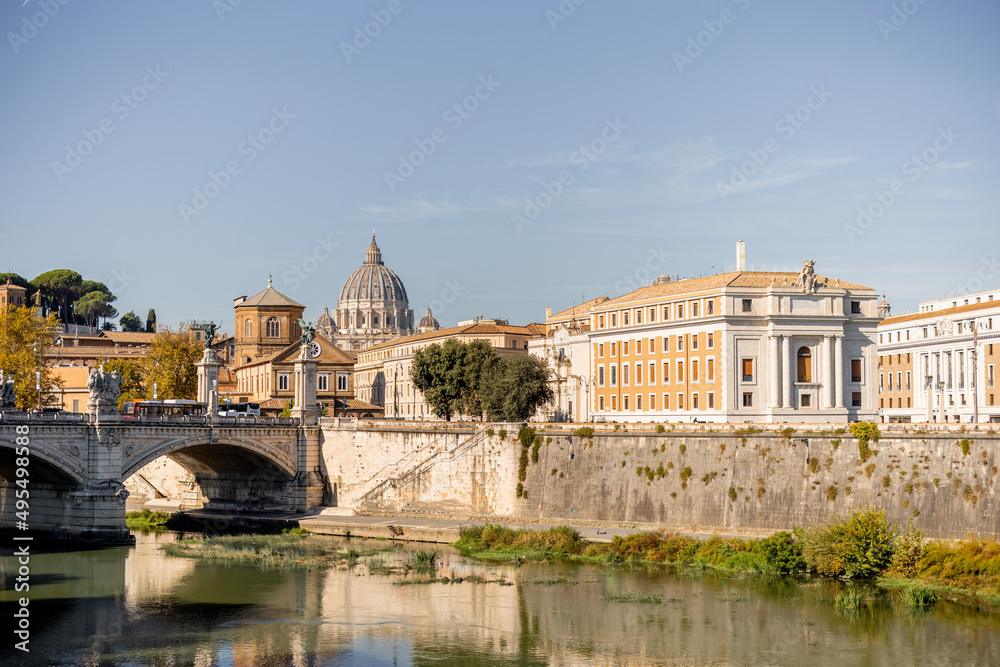 Landscape of Tiber river at sunny morning in Rome. Dome of famous saint Peter basalica on the skyline. Traveling Italy