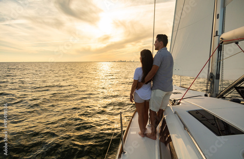Latin American couple relaxing on yacht at sunset