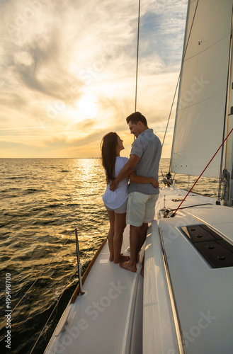 Loving young Hispanic couple on yacht at sunrise