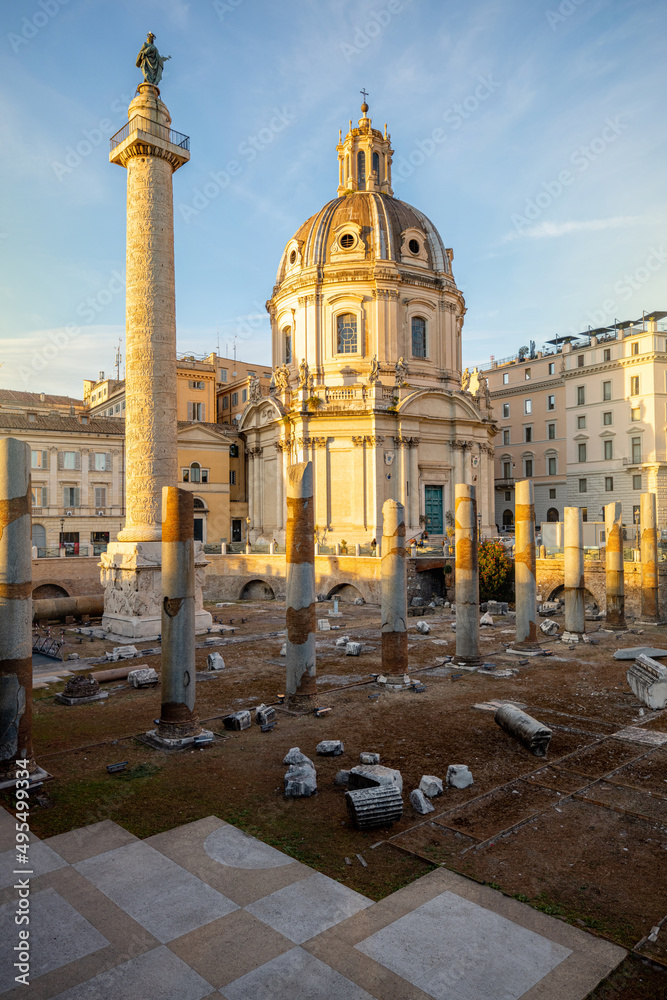 Ruins of Roman forum with Trajan column and church of the Most Holy Name of Mary. Rome cityscape on sunset. Concept of historical landmarks and travel Italy
