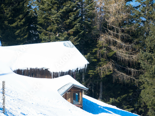 Wooden winter house covered with layers of snow. Old, impressive, snow-covered ski lodge in the austrian alps photo