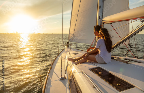 Hispanic couple relaxing on private yacht at sunrise