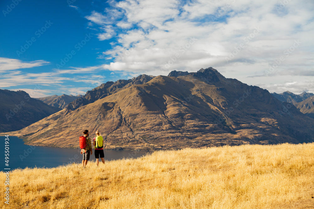 Male female hikers viewing Lake Wakatipu New Zealand