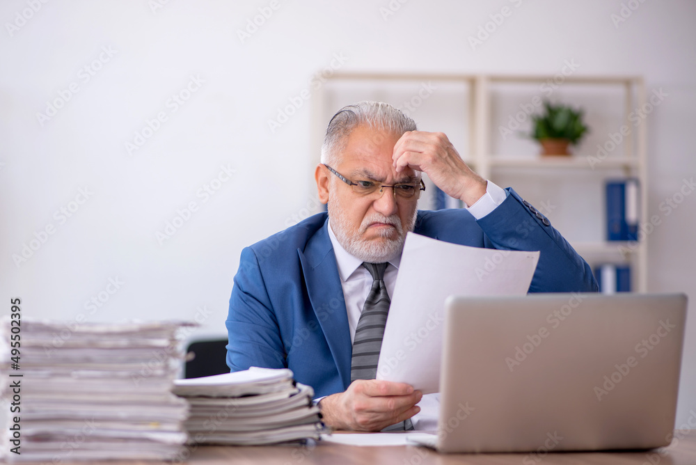 Old male employee and too much work in the office Old male employee and too much work in the office