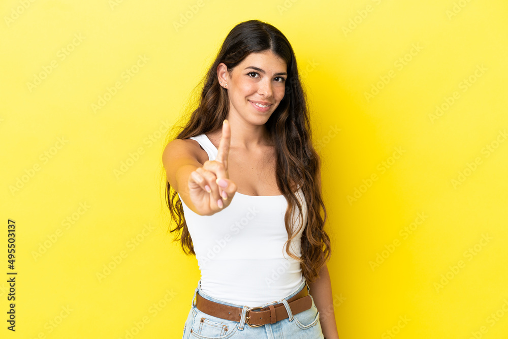 Young caucasian woman isolated on yellow background showing and lifting a finger Young caucasian woman isolated on yellow background showing and lifting a finger