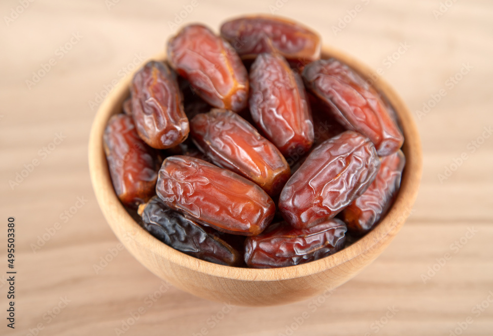 Date fruit in bowl on wooden background,directly above Date fruit in bowl on wooden background,directly above