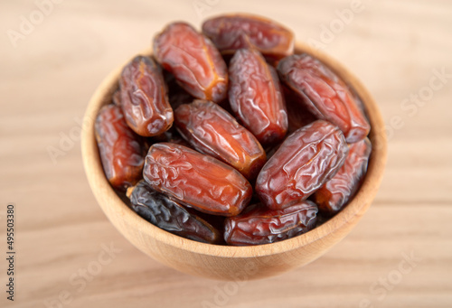 Date fruit in bowl on wooden background,directly above