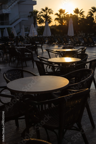 tables in a Turkish street cafe in the early morning light against the backdrop of palm trees