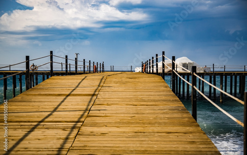 wooden pier in the mediterranean sea on a clear sunny day, view from below, perspective