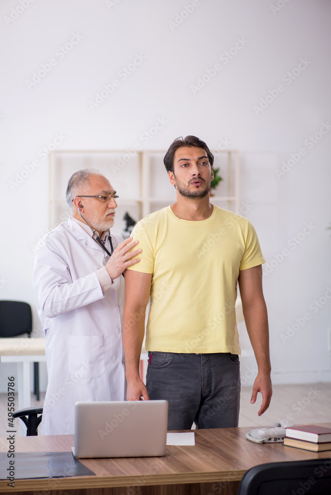 Obraz premium Young male patient visiting old male doctor