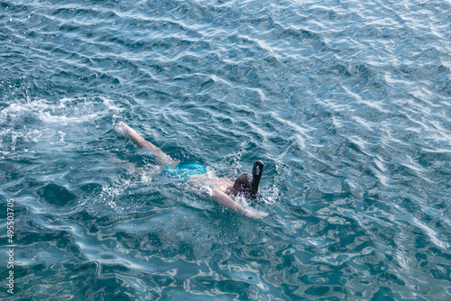boy in an underwater snorkel swims in the sea