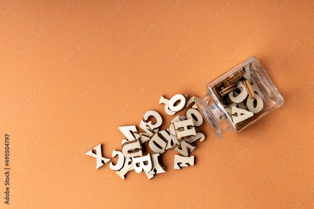 scattered letters on an orange background from a glass container scattered letters on an orange background from a glass container