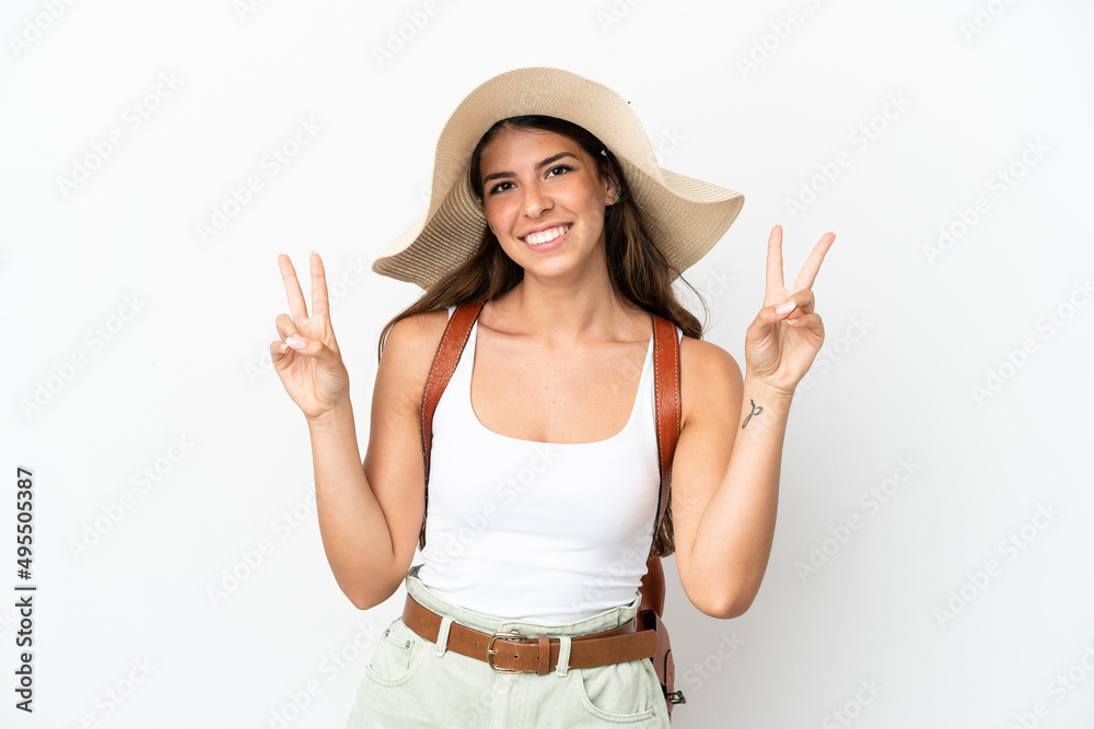 Young caucasian woman wearing a Pamela in summer holidays isolated on white background showing victory sign with both hands Young caucasian woman wearing a Pamela in summer holidays isolated on white background showing victory sign with both hands