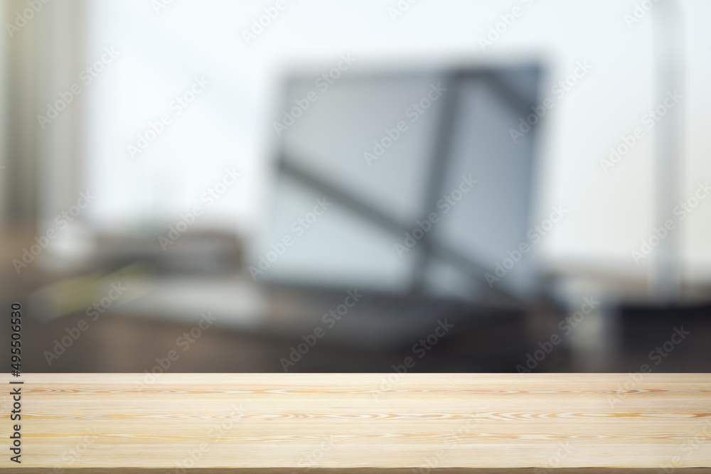 Empty wooden office table with light sunny workplace with computer on background, mockup