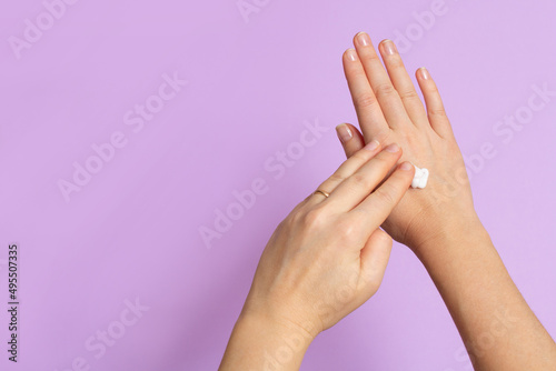 Using moisturizing cream on winter season concept. Top flatlay overhead above close up view photo of female girl hands smearing white smooth cream