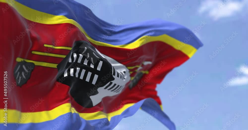 Detail of the national flag of Eswatini waving in the wind on a clear day.