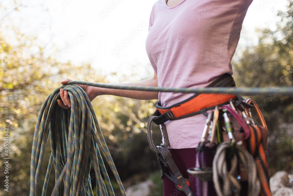 Naklejka premium A rock climber coils a rope