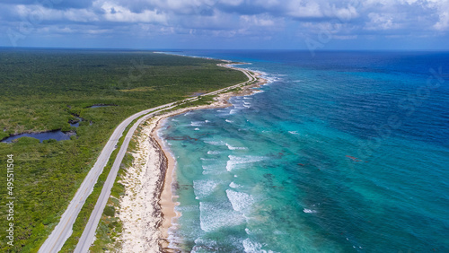 Aerial view of colorful turquoise ocean water from the Caribbean sea surrounding tropical island Cozumel in Quintana Roo, Mexico. A popular tourist destination.