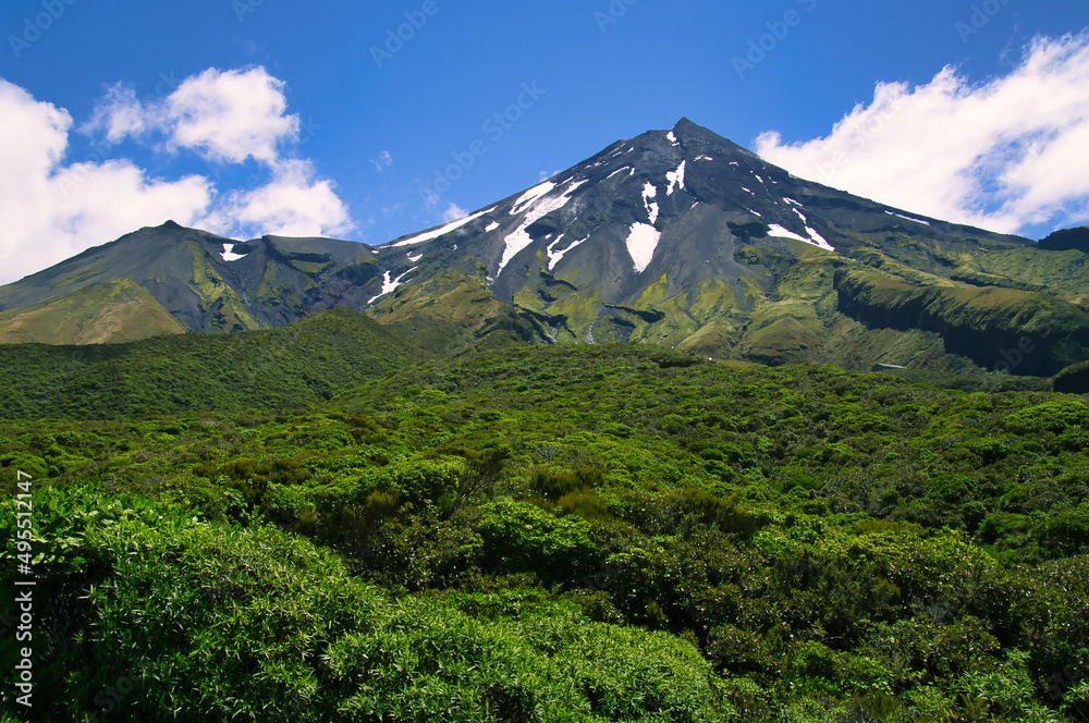 Mount Taranaki (Mount Egmont), a volcano on North Island, New Zealand, with dense cloud forests, scree and snowfields, on a clear day. 
