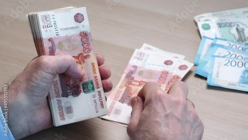 Close-up of hands counting five-thousandth banknotes of the Russian ruble. Men's hands count Russian money 5000 banknotes. business, finance
