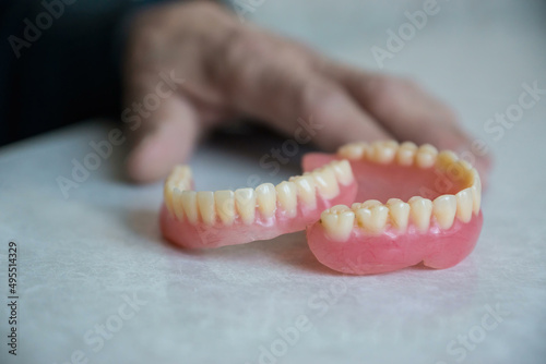 Close-up on the table lie false teeth artificial teeth removed by an elderly man. Selective focus, shallow depth of field