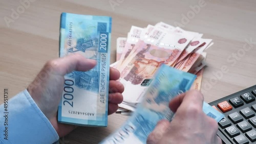 Men's hands count money, the currency is the Russian ruble. Concepts of finance and wealth. Banknotes of 2000 rubles in the hands of men. Investments, saving money.