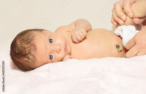 Mother treat newborn's baby navel with a cotton photo