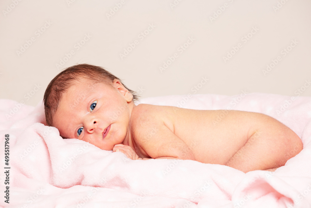 Portrait of a little newborn infant girl lay on her belly Portrait of a little newborn infant girl lay on her belly