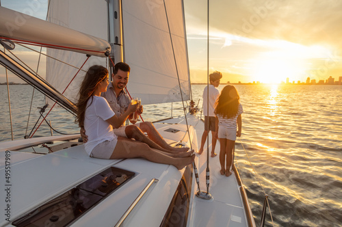 Hispanic family relaxing on luxury yacht at sunset photo