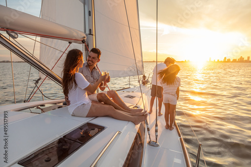 Young family having fun on yacht at sunset