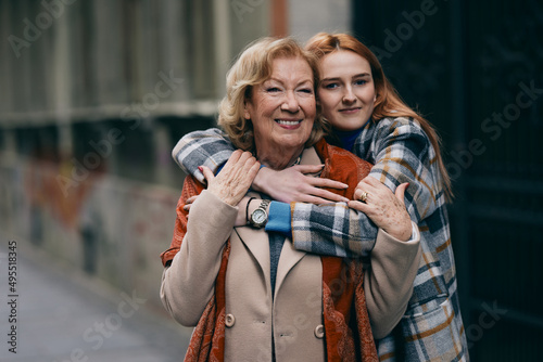 Εκτύπωση καμβά A happy grandmother and granddaughter hugs outside.