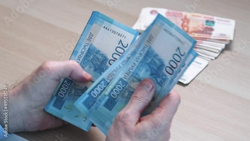 Men's hands count money, the currency is the Russian ruble. Concepts of finance and wealth. Banknotes of 2000 rubles in the hands of men. Investments, saving money.