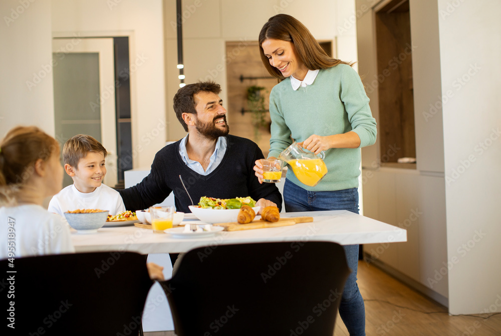 Young mother preparing breakfast for her family in the kitchen Young mother preparing breakfast for her family in the kitchen