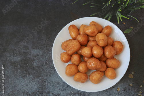 A bowl of Lokma (Turkish), loukoumades (Greeek ) with other names in other languages, are pastries made of leavened and deep fried dough, soaked in syrup or honey, sometimes coated with cinnamon