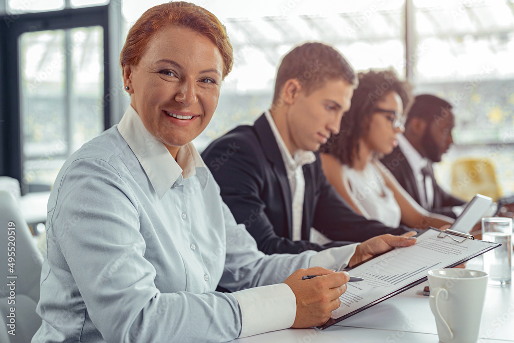 Smiling businesswoman holding tablet while working at office Smiling businesswoman holding tablet while working at office