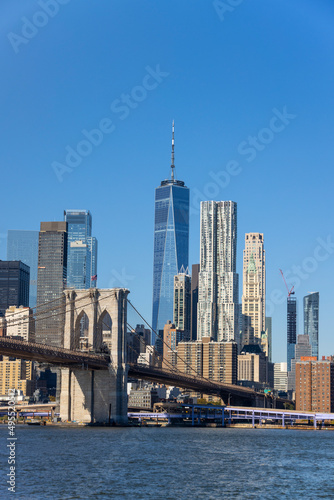 Lower Manhattan skyscraper stands behind Brooklyn Bridge beyond the East River on November 5, 2021 in New York City NY USA. NYC Ferry runs on East River. © STUDIO BONOBO