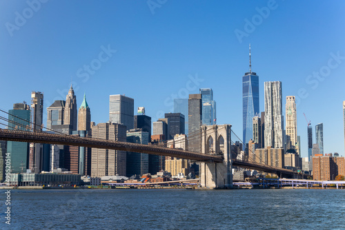 Lower Manhattan skyscraper stands behind Brooklyn Bridge beyond the East River on November 5, 2021 in New York City NY USA. NYC Ferry runs on East River. © STUDIO BONOBO