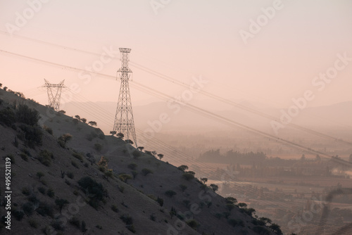 Paisaje del campo con cerros en el sur de chile en atardecer con torre de alta tensión