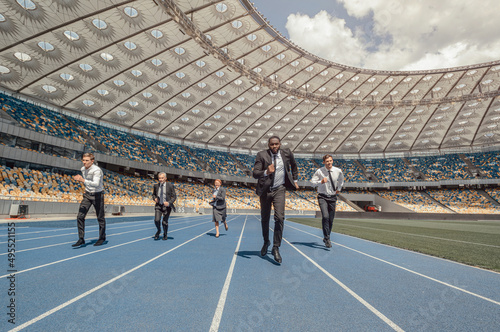 People in business suits running on modern sports track