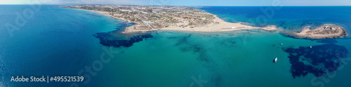 Fototapeta Naklejka Na Ścianę i Meble -  Aerial drone view of island and beach of Isola delle Correnti. Lighthouse surrounded by clear turquoise sea water in Portopalo di capo Passero, Sicily