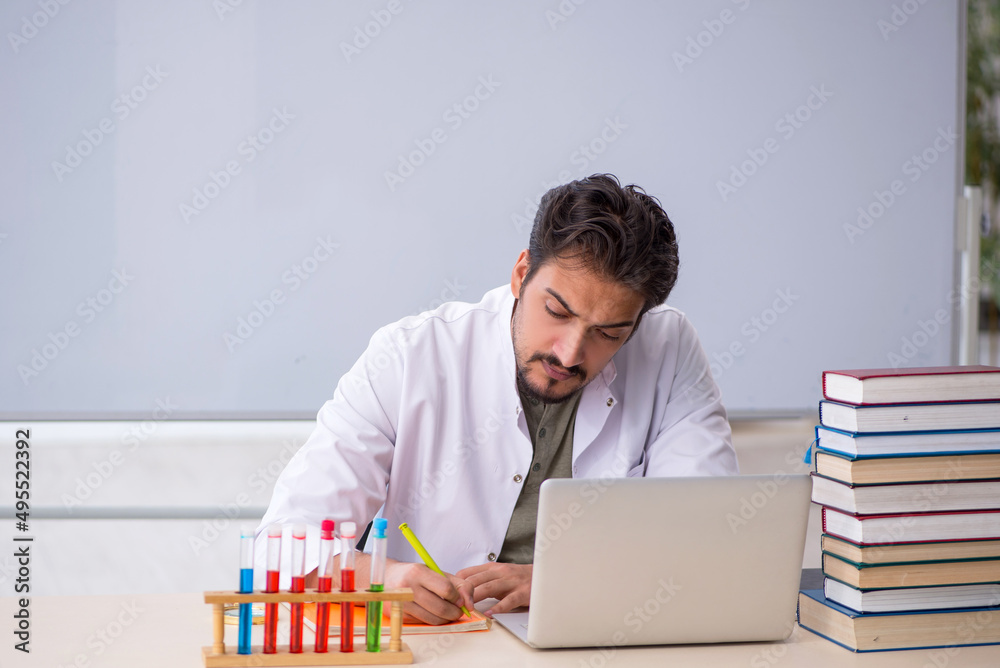 Young male chemist teacher in front of whiteboard Young male chemist teacher in front of whiteboard