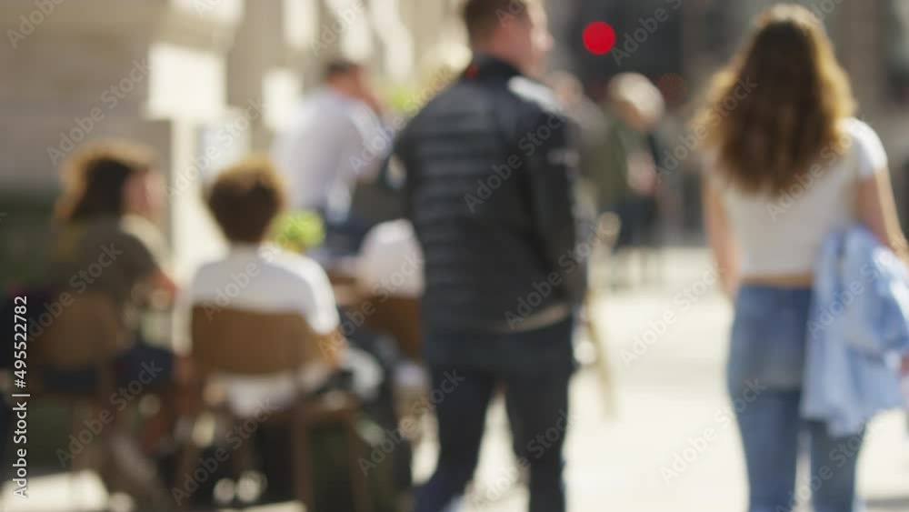 Blurred people sitting outside a cafe on a sunny day