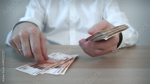 A man counts out a bundle of five thousand Russian ruble banknotes . Cash banknotes. The concept of bribery and corruption. Finance and investments. Close-up.