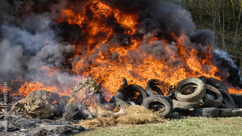 Burning landscape. Vehicle tires and haystacks on fire, black smoke invading the landscape...demonstrations against the environment photo