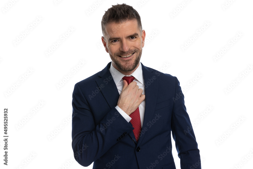 businessman with a wide smile is arranging his tie businessman with a wide smile is arranging his tie