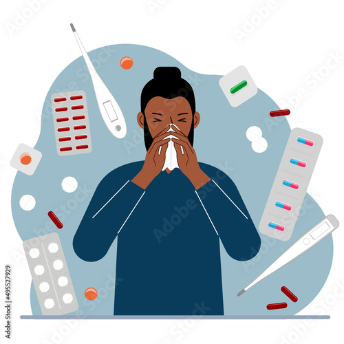 A man covers his nose with his hands with a handkerchief. The concept of a cold person, seasonal allergies. Lots of medicines and thermometers.