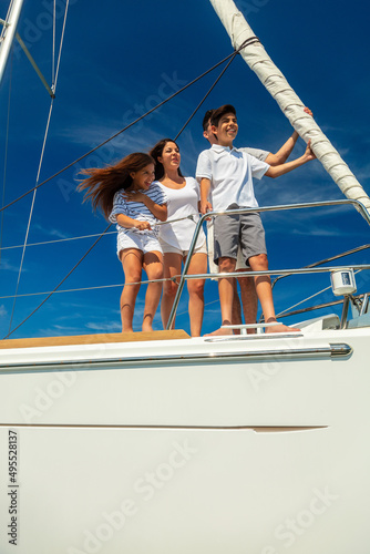 Smiling Latino family on yacht travelling the ocean