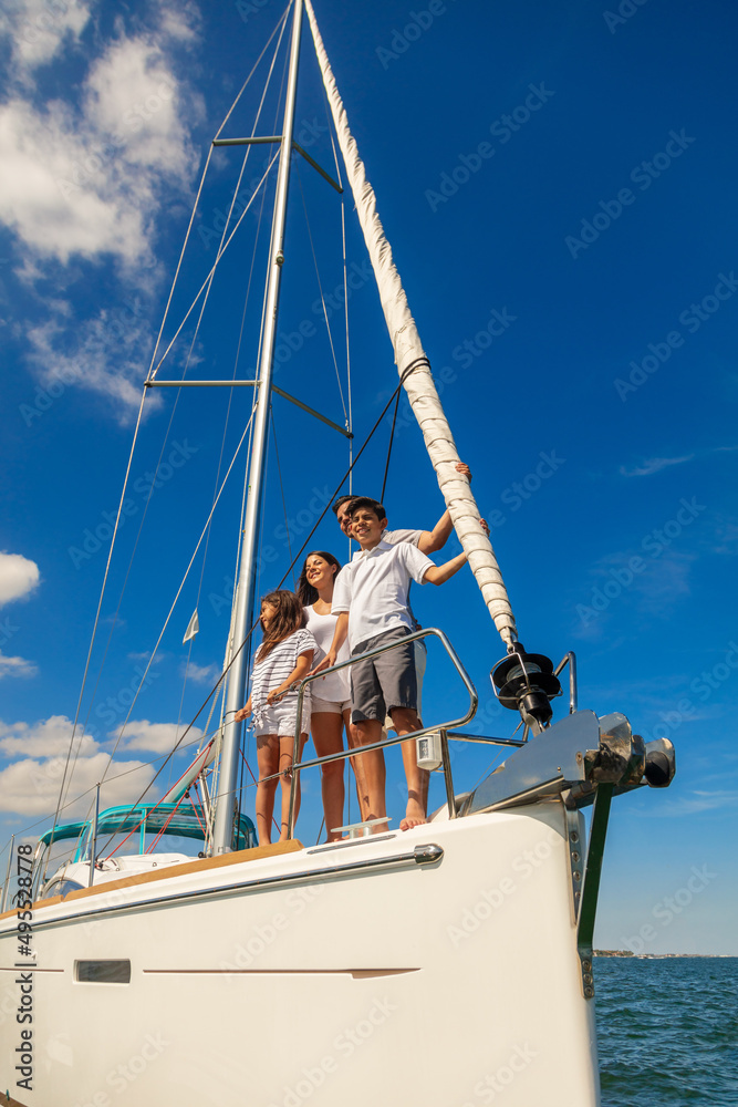 Latin American family standing on bow of yacht Latin American family standing on bow of yacht